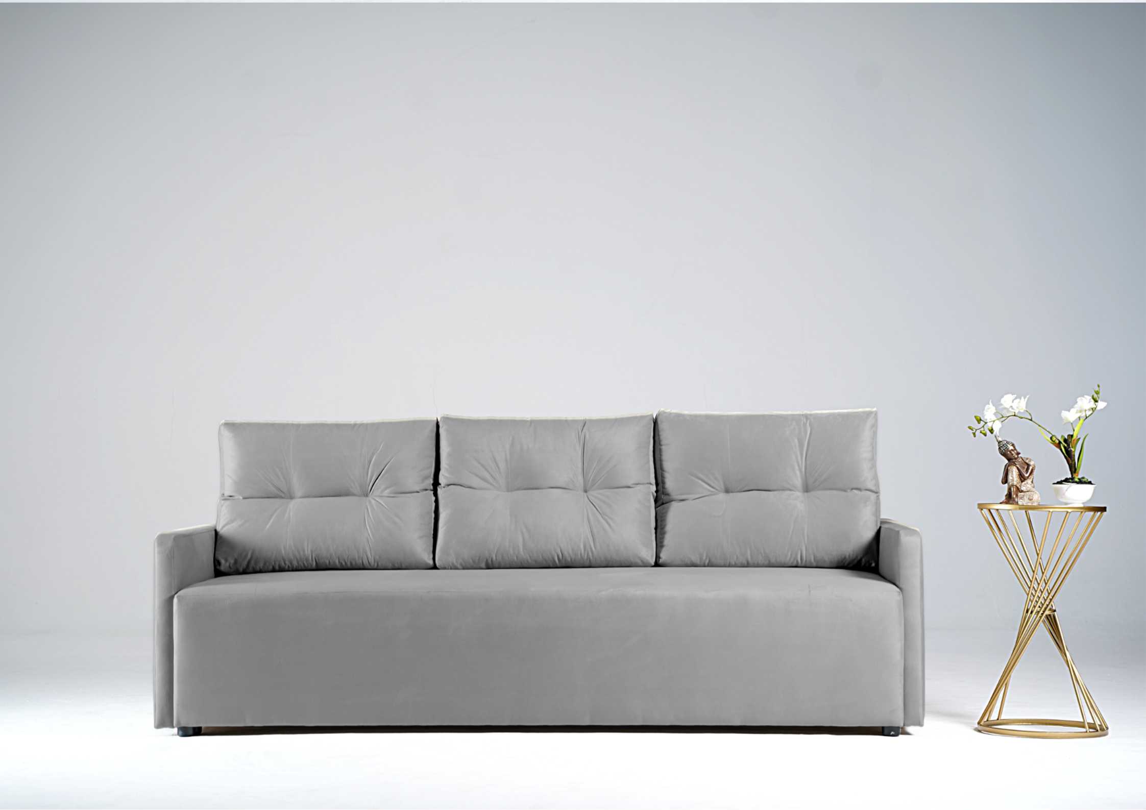 Szara sofa z pikowanymi poduszkami